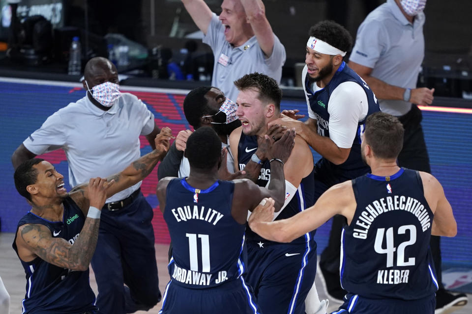 Luka Doncic is surrounded by his teammates in celebration after knocking down the winning 3-pointer.