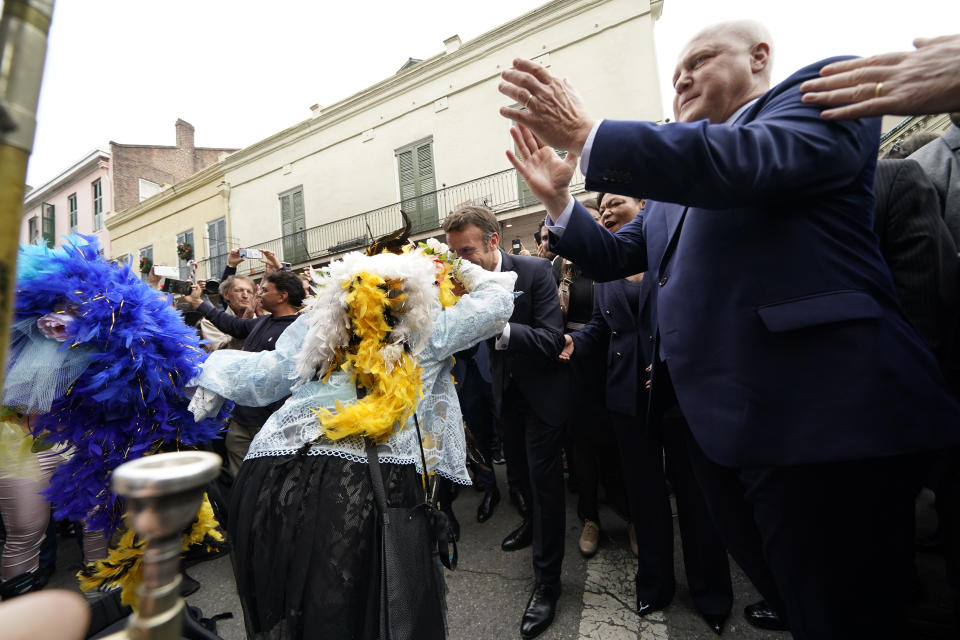 French President Emmanuel Macron kisses the hand of street performer Jennifer Jones as he walks down Royal St. in the French Quarter of New Orleans, Friday, Dec. 2, 2022. (AP Photo/Gerald Herbert)