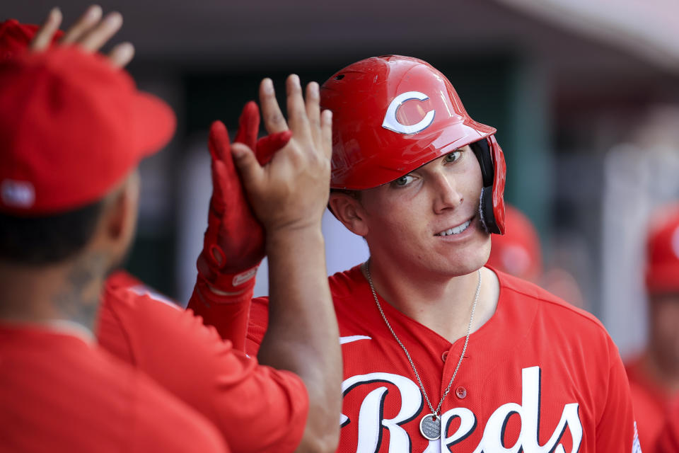 Cincinnati Reds' Tyler Stephenson high-fives teammates ini the dugout after hitting a solo home run during the eighth inning of a baseball game against the Atlanta Braves in Cincinnati, Saturday, June 26, 2021. (AP Photo/Aaron Doster)