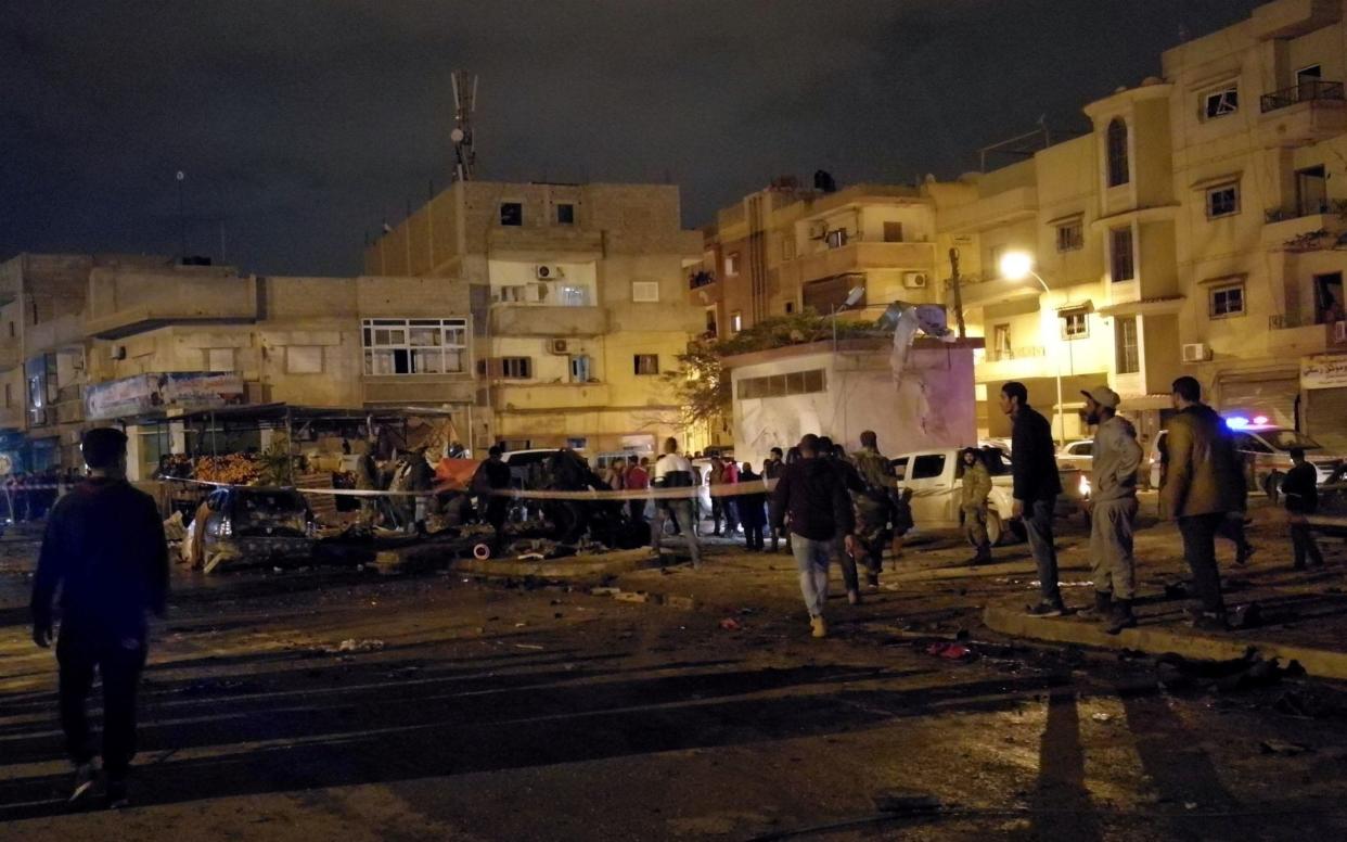 People gather at the site of twin car bombs in Benghazi, Libya, January 23  - REUTERS