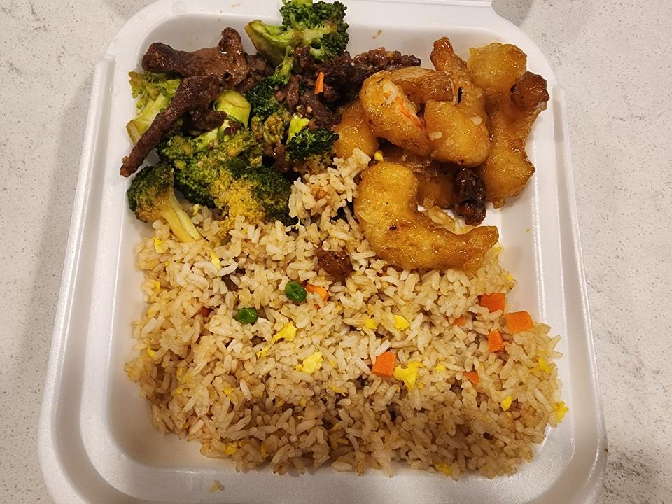 A bigger plate filled with fried rice, honey-walnut shrimp, and broccoli beef