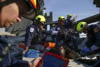 Rescue specialists for USA-1 work on a role playing patient rescued from the scene of a mock disaster area during a training exercise at the Guardian Center in Perry, Georgia, March 24, 2014. (REUTERS/Shannon Stapleton)