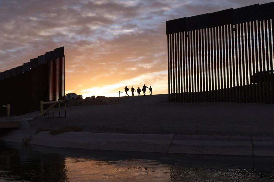 Migrants pass through a gap in the border wall near Yuma in Arizona (file) (Associated Press)