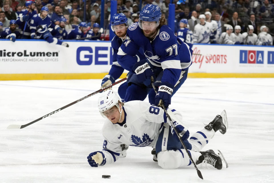 Toronto Maple Leafs right wing William Nylander (88) plays the puck from his knees in front of Tampa Bay Lightning defenseman Victor Hedman (77) and defenseman Nick Perbix (48) during the first period of an NHL hockey game Tuesday, April 11, 2023, in Tampa, Fla. (AP Photo/Chris O'Meara)