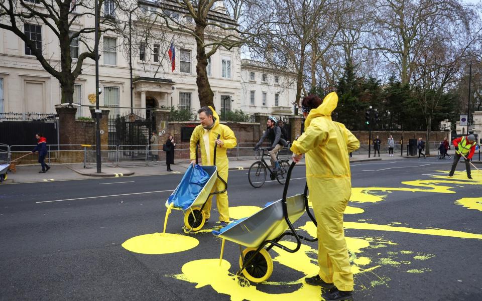 Protest group 'Led by Donkeys' pour yellow paint for the Ukrainian flag - REUTERS/Hannah McKay