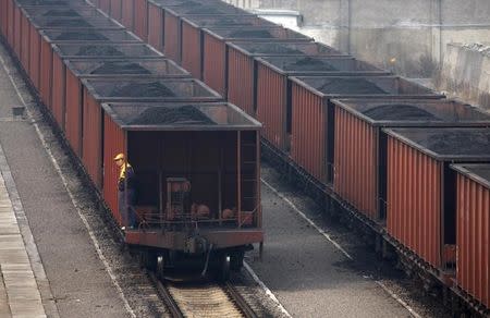 FILE PHOTO: A worker stands on a wagon of a coal train as it tranfers coal to a power plant in Huaibei, Anhui province November 17, 2011. REUTERS/Stringer
