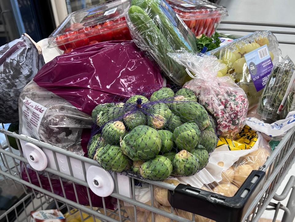 Full shopping cart with mostly produce and dairy products