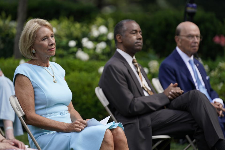 From left, Education Secretary Betsy DeVos, Housing and Urban Development Secretary Ben Carson and Commerce Secretary Wilbur Ross listen as President Donald Trump speaks before signing an executive order on the "White House Hispanic Prosperity Initiative," in the Rose Garden of the White House, Thursday, July 9, 2020, in Washington. (AP Photo/Evan Vucci)