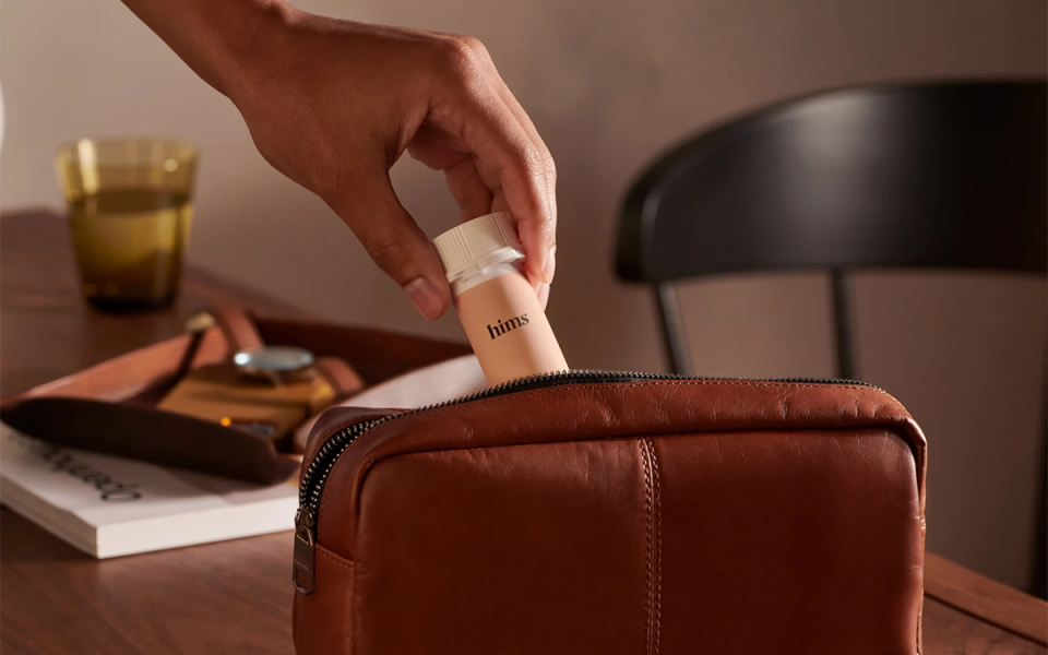 hims oral finasteride being placed into a toiletry bag