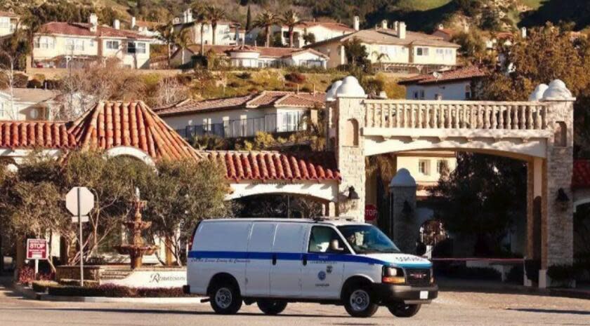 A coroner's van leaves the Renaissance gated community, where Los Angeles police investigated a triple homicide in February. Police arrested a man and woman this week in Maryland and another man in North Carolina. (Al Seib / Los Angeles Times)