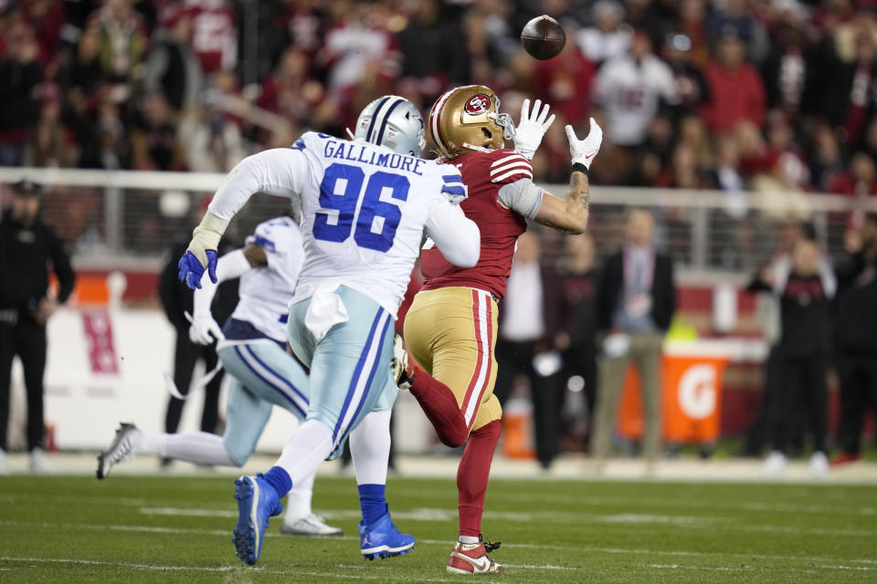 San Francisco 49ers tight end George Kittle, right, catches a pass in front of Dallas Cowboys defensive tackle Neville Gallimore (96) during the second half of an NFL divisional round playoff football game in Santa Clara, Calif., Sunday, Jan. 22, 2023. (AP Photo/Godofredo A. Vásquez)