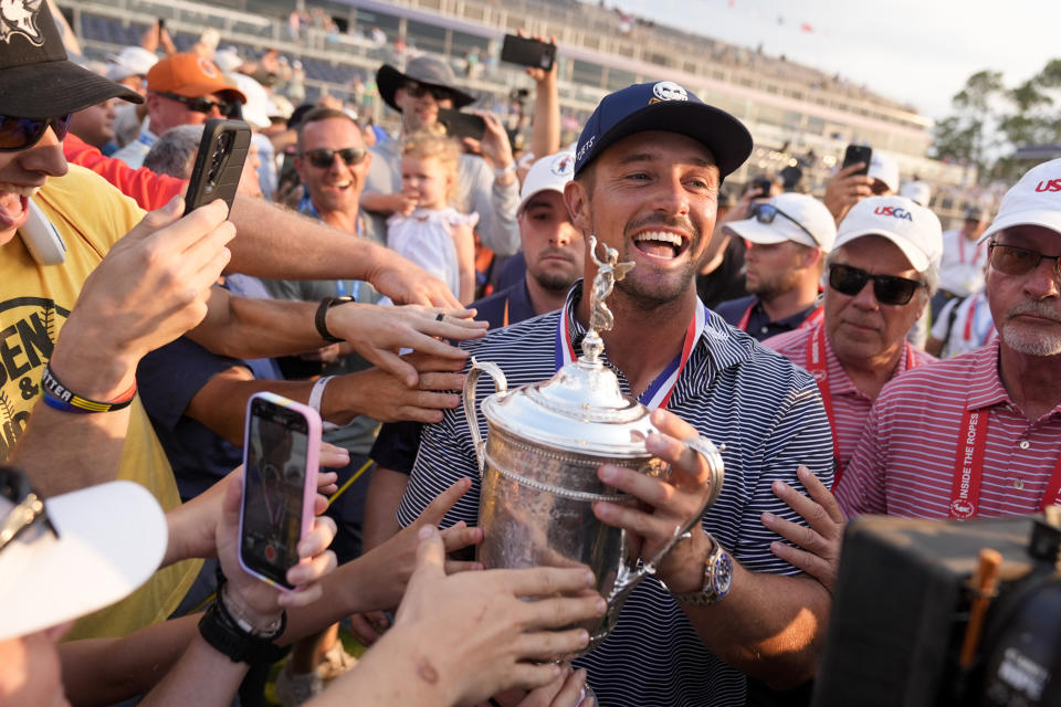 Bryson DeChambeau celebrates with fans and the trophy after winning the U.S. Open golf tournament Sunday, June 16, 2024, in Pinehurst, N.C. (AP Photo/Frank Franklin II)