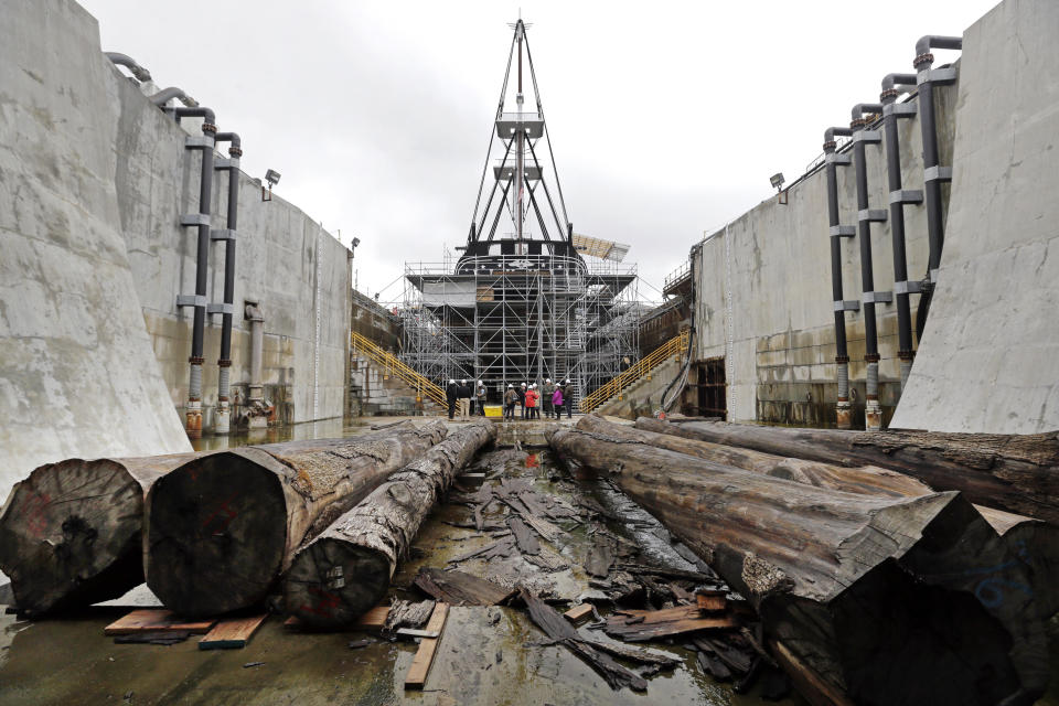 Cut oak trees lay before the USS Constitution in dry dock as restoration is ongoing, Wednesday, April 5, 2017, at the Charlestown Navy Yard in Boston. The ship enters dry dock for below-the-waterline repairs every 20 years. The world's oldest commissioned warship afloat, is scheduled to return to the waters in late July. (AP Photo/Elise Amendola)