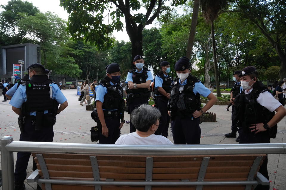 Police officers stop and search a woman at the Hong Kong's Victoria Park, Saturday, June 4, 2022. Dozens of police officers patrolled Hong Kong's Victoria Park on Saturday after authorities for a second consecutive third banned public commemoration of the anniversary of the Tiananmen Square crackdown in 1989, amid a crackdown on dissent in the city. (AP Photo/Kin Cheung)