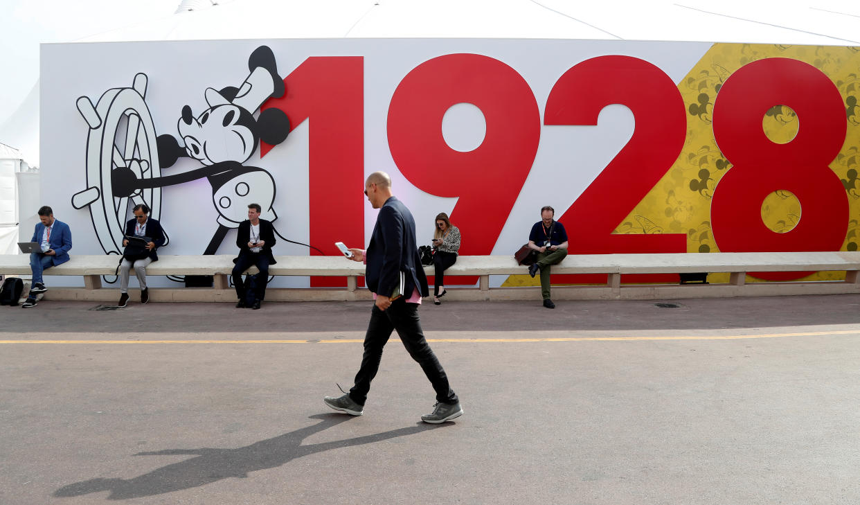 A visitor walks past a mural depicting Disney character Mickey Mouse to celebrate his 90th birthday during the annual MIPCOM television programme market in Cannes, France, October 15, 2018. 