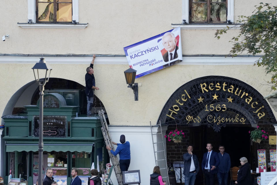 Workers hoisting campaign banner of ruling PiS (Law and Justice) leader Jaroslaw Kaczynski, who is running in crucial parliamentary election, in Sandomierz, Poland, Friday, Oct. 13, 2023. At stake in Sunday's vote are the health of the nation's democracy, strained under the ruling conservative Law and Justice party, and the foreign alliances of a country on NATO's eastern flank that has been a crucial ally. The main challenger is centrist Civic Coalition. (AP Photo/Czarek Sokolowski)