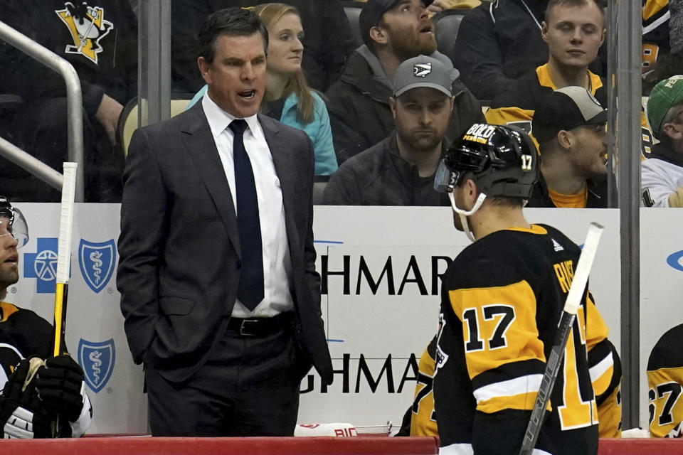 Pittsburgh Penguins head coach Mike Sullivan talks with right wing Bryan Rust (17) as they take on the New York Islanders during the second period of an NHL hockey game in Pittsburgh, Monday, Feb. 20, 2023. (AP Photo/Matt Freed)