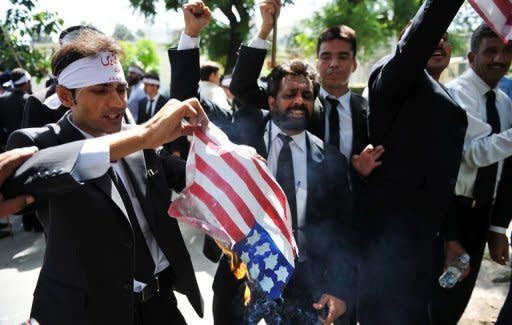 Pakistani lawyers burn a US flag as they attempt to reach the US embassy in the diplomatic enclave during a protest against an anti-Islam movie in Islamabad. As protests again erupted across the Muslim world on Wednesday over an anti-Islam film, a French magazine poured fuel on the fire by publishing obscene cartoons depicting the Prophet Mohammed