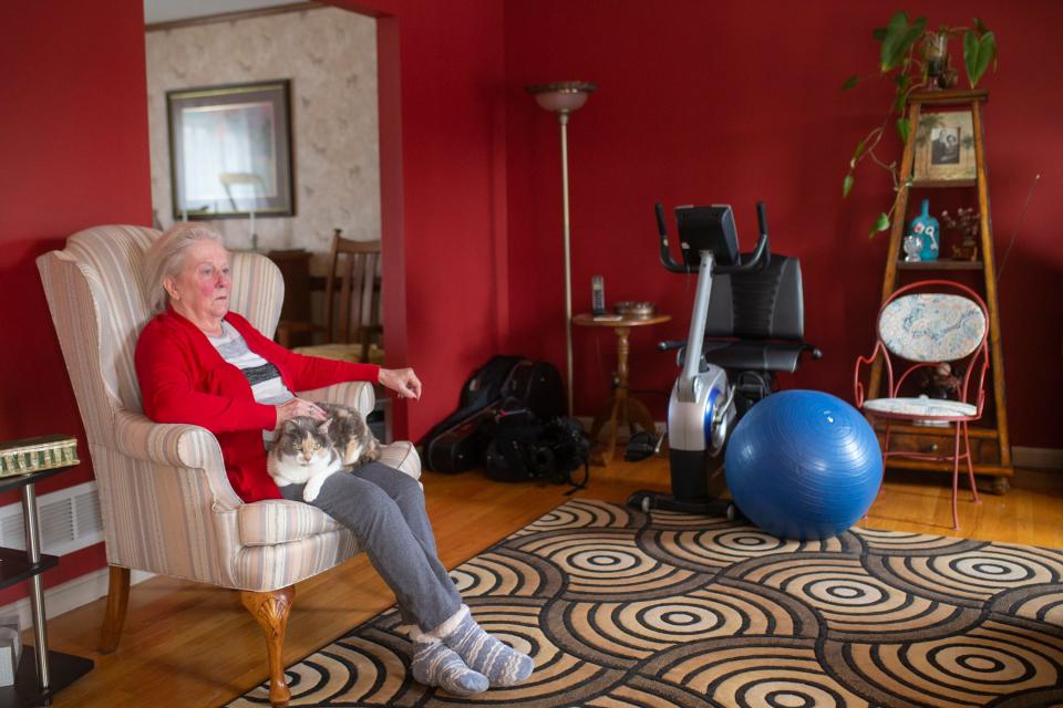 Sue Lee, 77, sits with her cat, Cali, in the living room of her home in Crestwood, Ky.