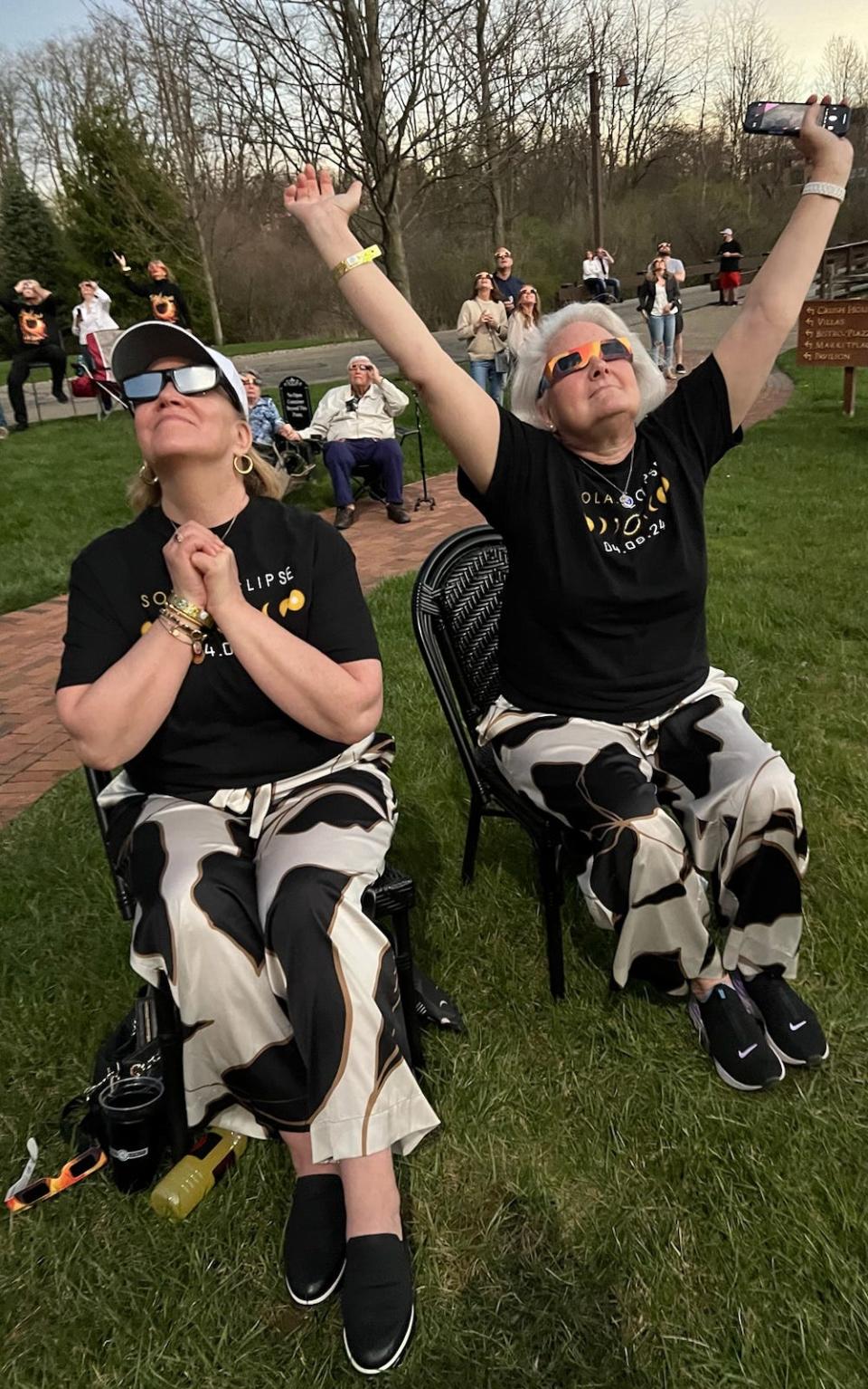 Joan Smith, right, of St. Paul, Minnesota, and Tama Ann of Columbus celebrate as the moon crossed in front of the sun for a total solar eclipse Monday at Gervasi Vineyard Resort & Spa in Canton.