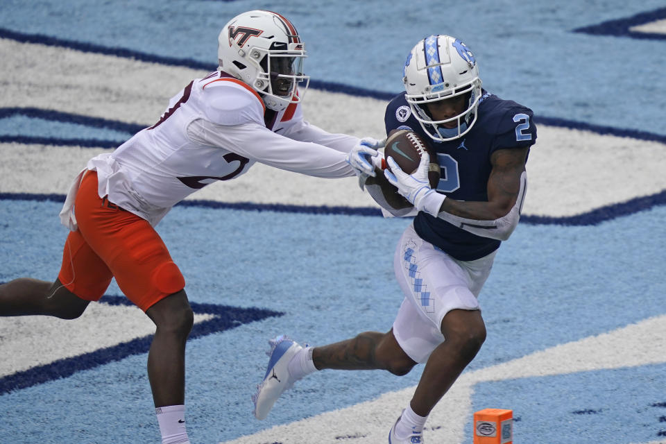 North Carolina wide receiver Dyami Brown (2) scores a touchdown as Virginia Tech defensive back Armani Chatman (27) chases during the first half of an NCAA college football game in Chapel Hill, N.C., Saturday, Oct. 10, 2020. (AP Photo/Gerry Broome)