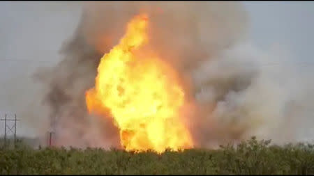 FILE PHOTO: A pipeline explosion erupts in this image captured from video by a field worker in Midland County, the home to the Permian Basin and the largest U.S. oilfield, in Texas, U.S., August 1, 2018. Courtesy Marty Baeza/Handout via REUTERS/File Photo