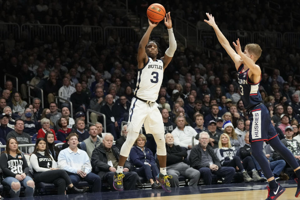 Butler guard Chuck Harris, left, shoots in front of Connecticut guard Joey Calcaterra, right, in the first half of an NCAA college basketball game in Indianapolis, Saturday, Dec. 17, 2022. (AP Photo/AJ Mast)