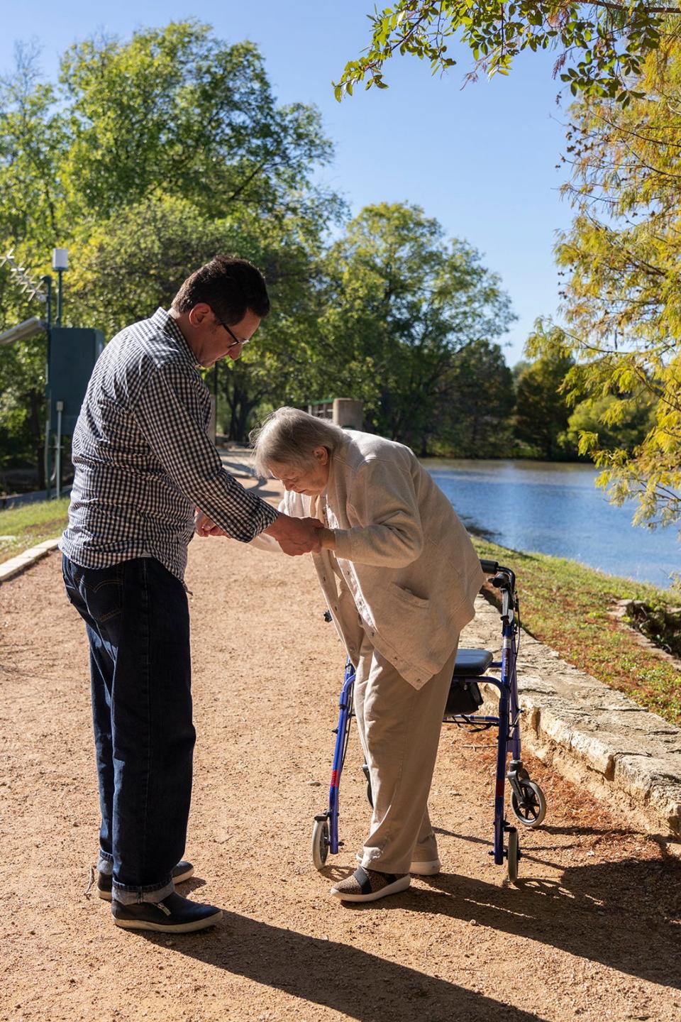 Scott Harvey, 52,  helps his mother, Sheri Harvey, 79, with her walker on Wednesday, Oct. 26, 2022. Sheri Harvey has debilitating arthritis that requires nursing care. Her son Scott has tried to keep her in care, which has meant draining their savings.