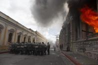 Flames shoot out from the Congress building after protesters set a part of the building on fire, in Guatemala City, Saturday, Nov. 21, 2020. Hundreds of protesters were protesting in various parts of the country Saturday against Guatemalan President Alejandro Giammattei and members of Congress for the approval of the 2021 budget that reduced funds for education, health and the fight for human rights. (AP Photo/Oliver De Ros)