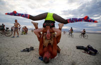 <p>Mark Dill and Brit Thacker practice acro-yoga as approximately 70,000 people from all over the world gather for the 30th annual Burning Man arts and music festival in the Black Rock Desert of Nevada, Aug. 29, 2016. (REUTERS/Jim Urquhart)</p>