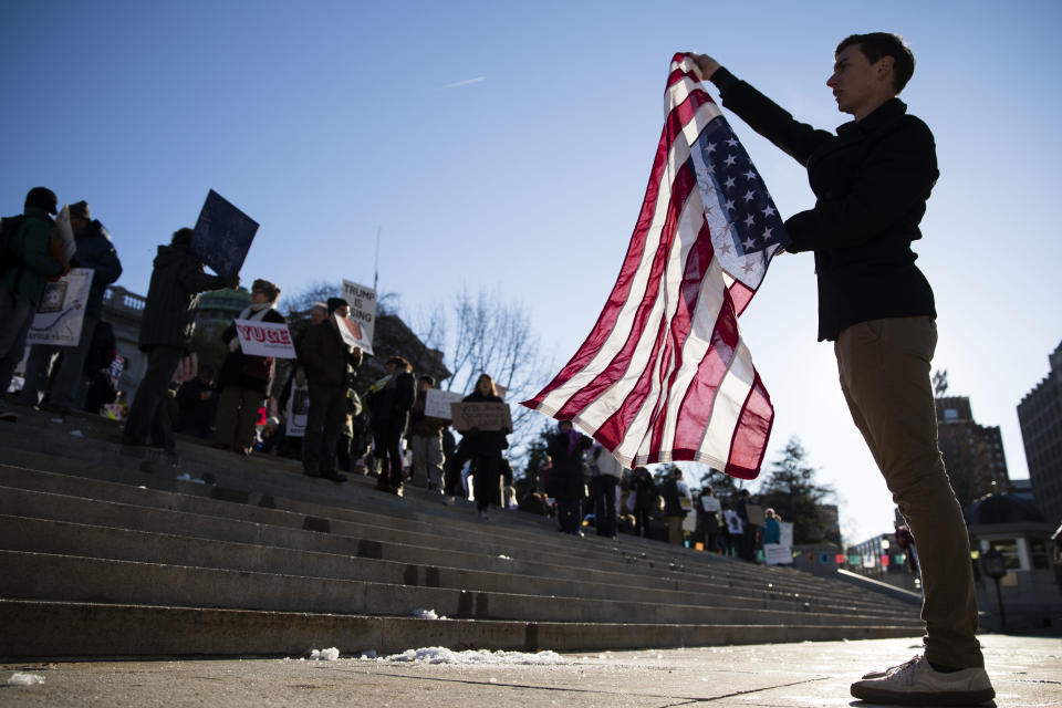 Protesters demonstrate ahead of Pennsylvania's 58th Electoral College at the state Capitol in Harrisburg, Pa., Monday, Dec. 19, 2016. The demonstrators were waving signs and chanting in freezing temperatures Monday morning as delegates began arriving at the state Capitol to cast the state's electoral votes for president. (AP Photo/Matt Rourke)