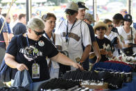 Gail Edmund of Northbound, Wash., left, purchases baseball souvenirs for friends before a Baseball Hall of Fame induction ceremony at the Clark Sports Center on Sunday, July 21, 2019, in Cooperstown, N.Y. (AP Photo/Hans Pennink)