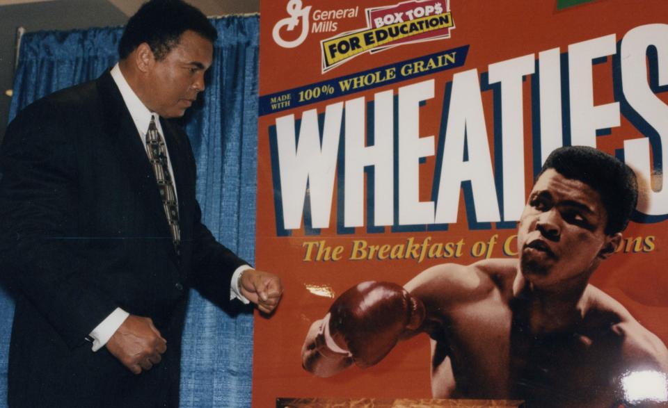 Muhammed Ali mirrors the boxing stance featured on the cover of the iconic 1999 Wheaties box on stage during a press conference at Madison Square Garden (credit: General Mills archives)