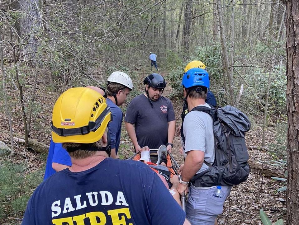 Saluda Fire & Rescue firefighters carry a hiker from the Big Bradley Falls area after the hiker injured his leg in a fall on April 1.