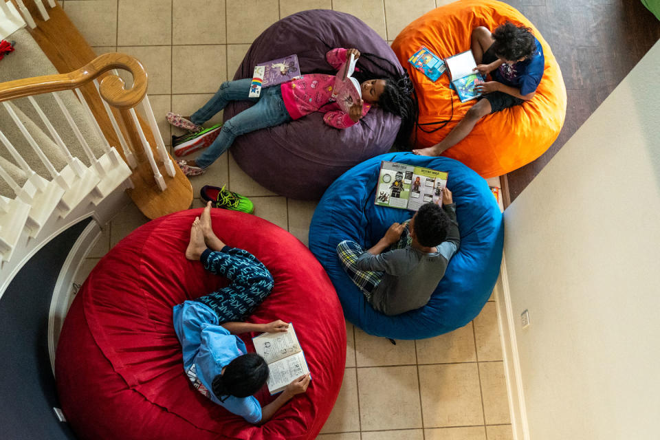 Four of the Thomas siblings read in beanbag chairs in the entryway of the family's home.<span class="copyright">Ilana Panich-Linsman for TIME</span>