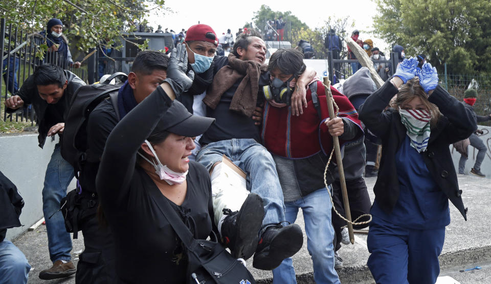 An injured anti-government protester is carried away during clashes with police near the National Assembly in Quito, Ecuador, Tuesday, Oct. 8, 2019. Anti-government protests, which began when President Lenín Moreno’s decision to cut subsidies led to a sharp increase in fuel prices, has persisted for days, and clashes led the president to move his besieged administration out of Quito. (AP Photo/Dolores Ochoa)