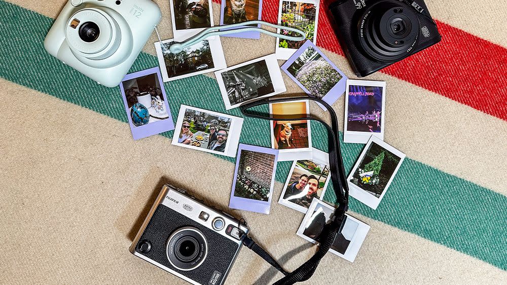 three instant cameras with a variety of polaroids