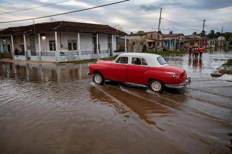 Un antiguo automóvil estadounidense atraviesa una zona inundada de Batabanó, Provincia Mayabeque, Cuba, el 28 de agosto de 2023, mientras la Tormenta Tropical Idalia se acerca a la punta occidental de la nación isleña.
