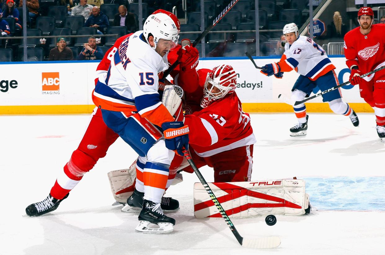 Red Wings goalie Ville Husso makes the save on the Islanders' Cal Clutterbuck during the second period on Monday, Oct. 30, 2023, in Elmont, New York.