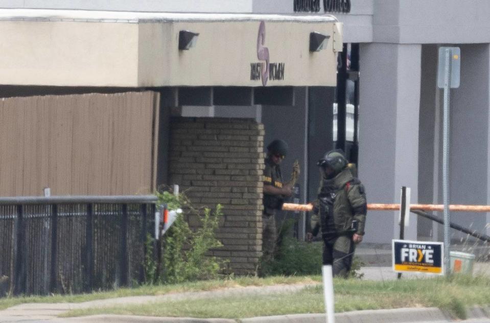 Bomb squad members work around the north side of the Trust Women clinic between Oliver and Edgemoor on Wednesday afternoon. A suspicious package at the clinic resulted in the total shutdown of Kellogg during the morning commute out of an abundance of caution while law enforcement investigated the scene.