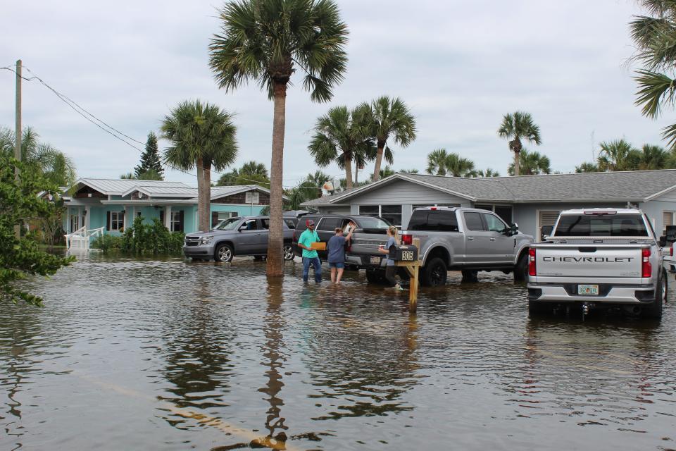 Flagler Beach residents and friends clean up Friday following Tropical Storm Ian's flooding.