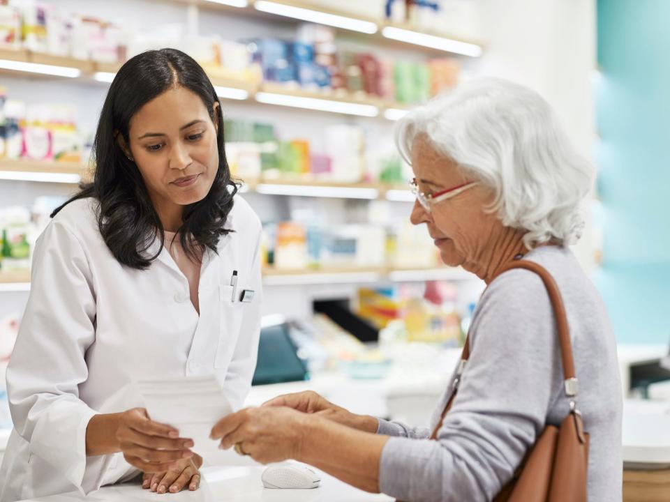 Customer showing prescription to pharmacist