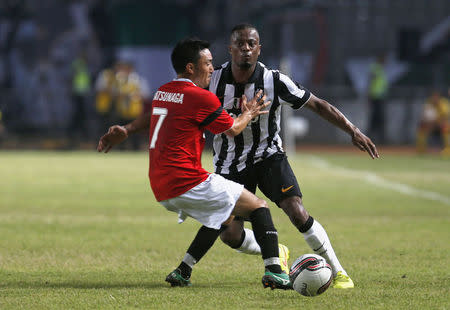 Juventus' Patrice Evra (R) fights for the ball against Indonesia Super League (ISL) All-Stars' Shohei Matsunaga during their friendly soccer match in Jakarta, August 6, 2014. REUTERS/Beawiharta