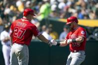 Mar 31, 2019; Oakland, CA, USA; Los Angeles Angels Mike Trout (27) greets Kole Calhoun (56) after he hit a solo home run against the Oakland Athletics during the inning of a Major League Baseball game at Oakland Coliseum. Mandatory Credit: D. Ross Cameron-USA TODAY Sports