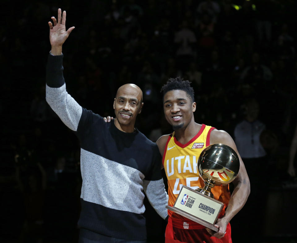 Utah Jazz guard Donovan Mitchell (45) holds the slam dunk contest trophy as he stands next to former Jazz player Darrel Griffith before the team’s NBA basketball game against the Portland Trail Blazers on Friday, Feb. 23, 2018, in Salt Lake City. (AP Photo/Rick Bowmer)