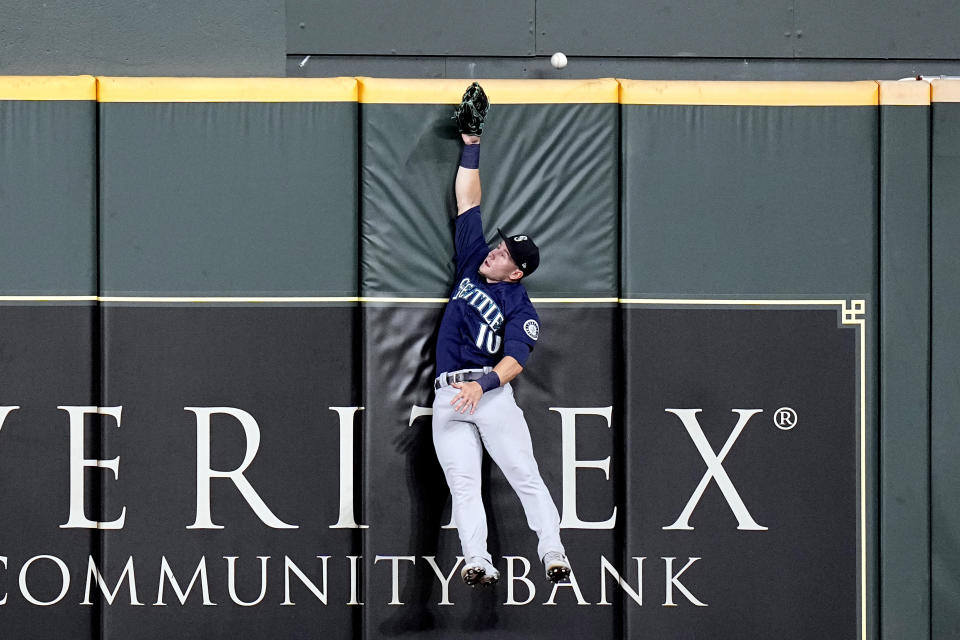 Seattle Mariners center fielder Jarred Kelenic leaps at the wall while trying to catch a two-run home run by Houston Astros' Jake Meyers during the second inning of a baseball game Friday, Aug. 20, 2021, in Houston. (AP Photo/David J. Phillip)