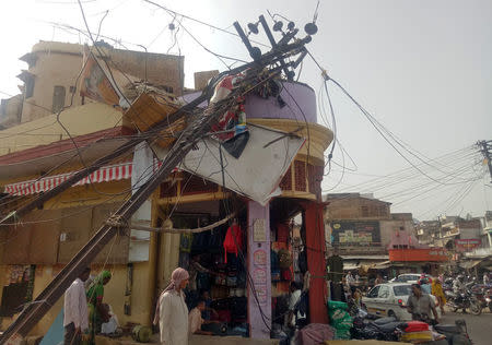 A damaged electric pole is pictured in a market after strong winds and dust storm in Alwar, in Rajasthan, India May 3, 2018. REUTERS/Stringer