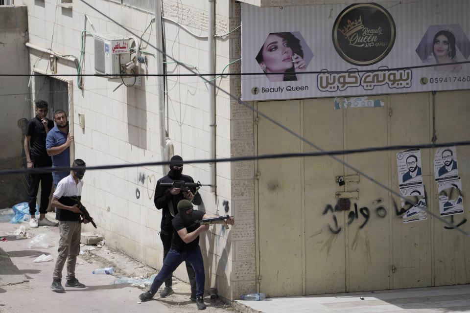 Palestinian gunmen take aim during an Israeli military operation in the West Bank town of Jenin, Friday, May 13, 2022. Israeli troops pushed into Jenin early Friday following the death of veteran Al Jazeera correspondent Shireen Abu Akleh on Wednesday when she was shot dead by Israeli forces while covering a military operation in the occupied West Bank. (AP Photo/Majdi Mohammed)