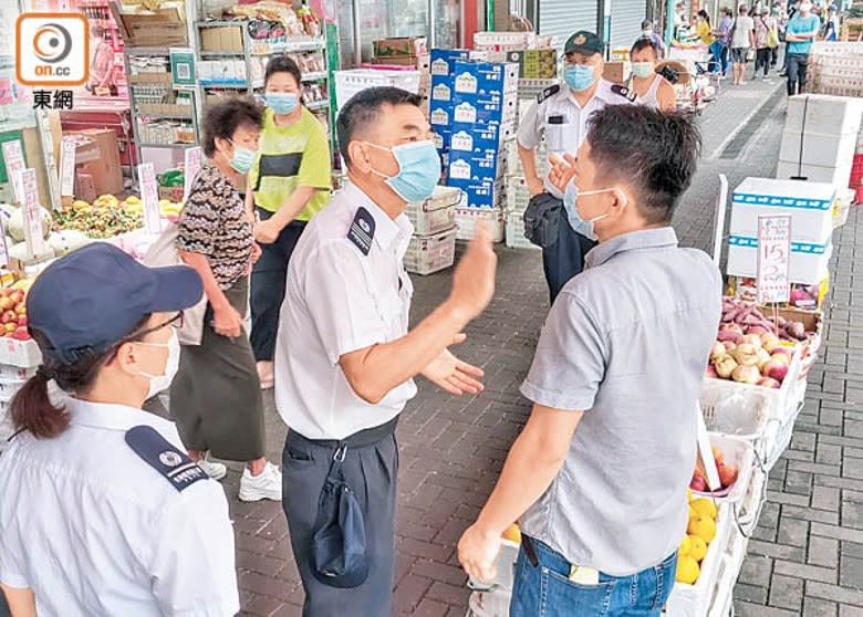 食環署人員向涉事雜貨店發出阻街告票。