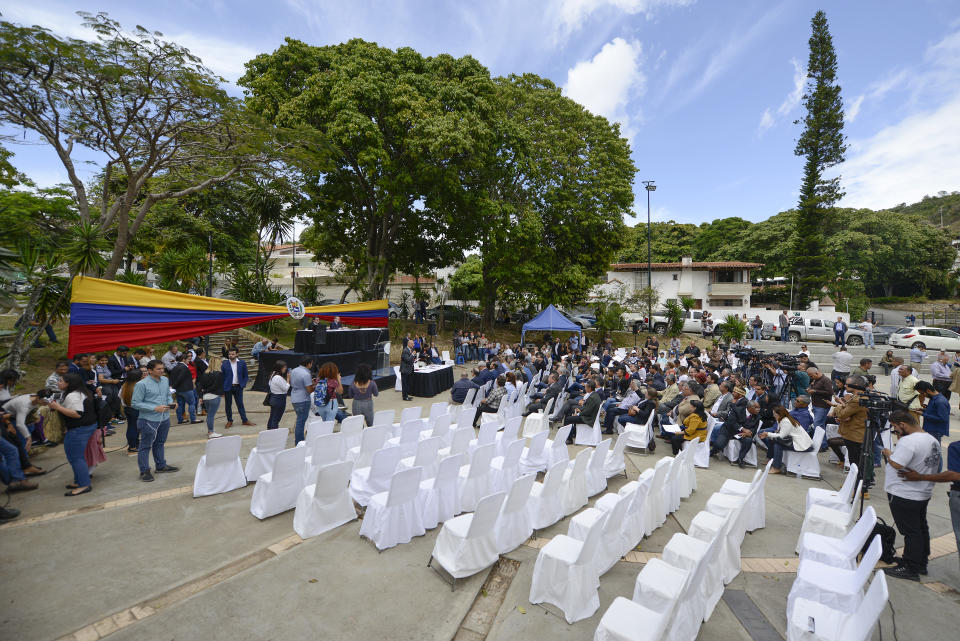 Opposition lawmakers hold a legislative session without the presence of government-allied lawmakers, which left many chairs empty, at a square in the Cumbres de Curumo neighborhood of Caracas, Venezuela, Tuesday, Jan. 21, 2020. Venezuelan lawmakers opposed to President Nicolás Maduro called off an attempt to hold a session in the national congress building on Tuesday, saying they wanted to avoid clashes with security forces and armed government supporters blocking entry. (AP Photo/Matias Delacroix)
